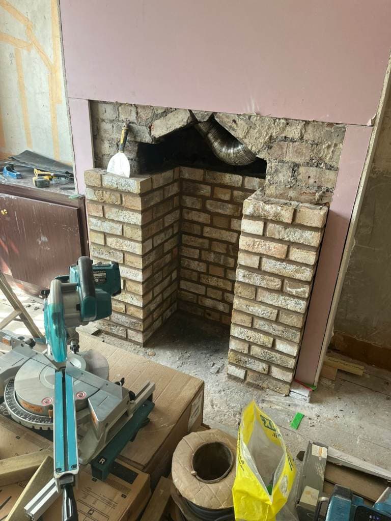 Brick fireplace opening rebuilt from scratch, mid-construction